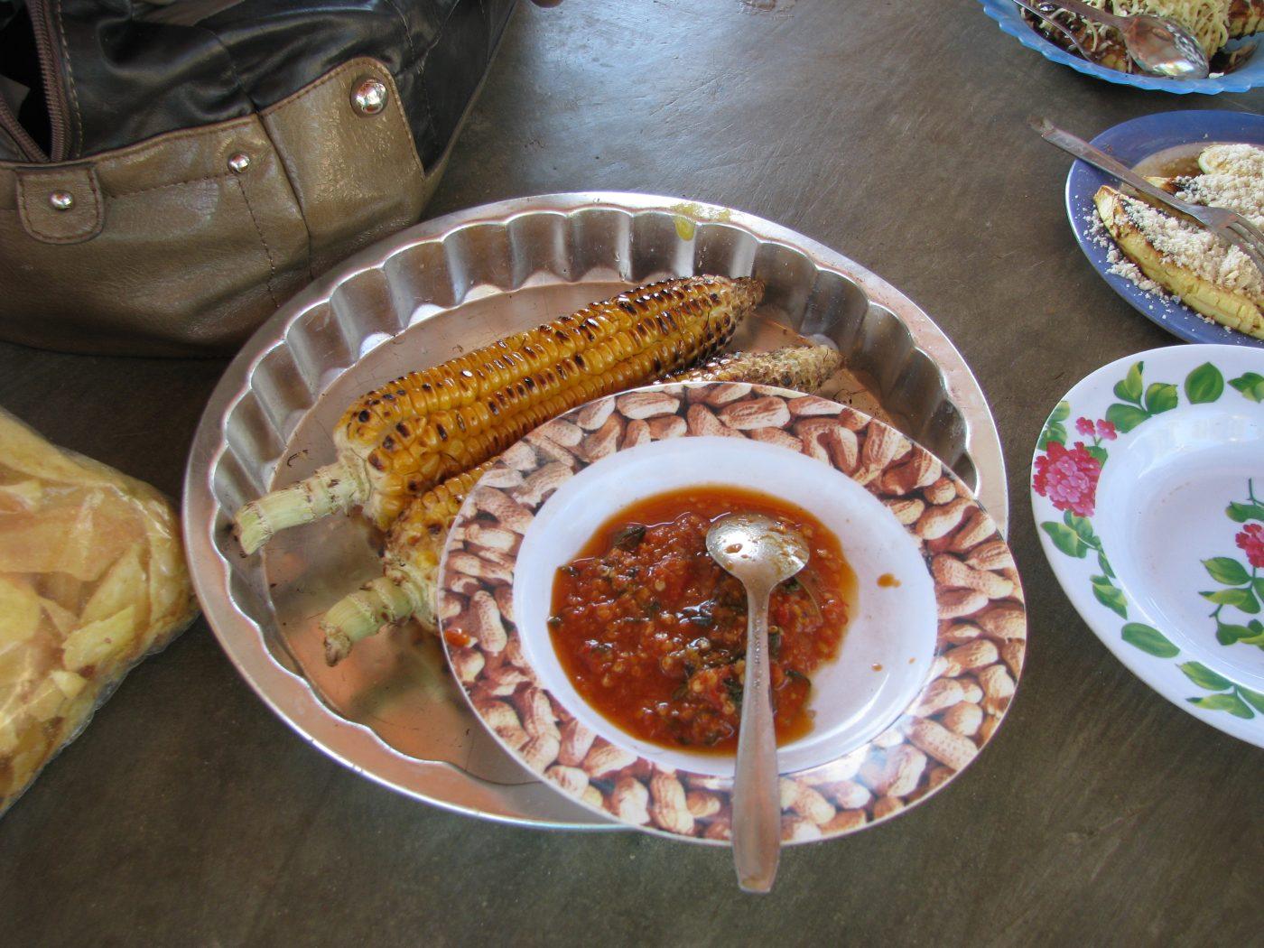 plate of grilled corn with spicy sambal