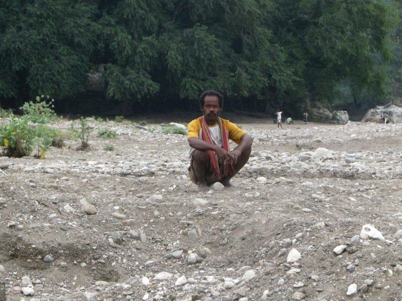 Man squatting as he stares at us. Typical experience when you're living in Bali as an expat.