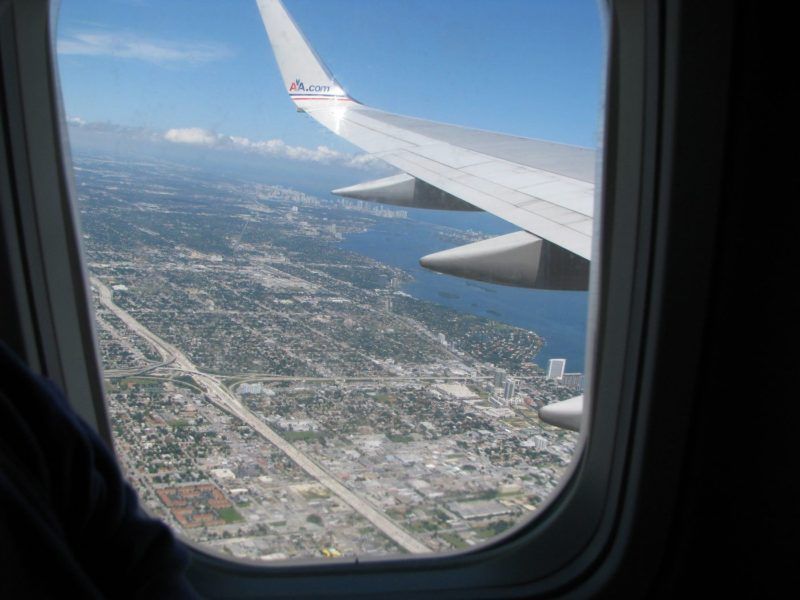 View of a wing and ground below airplane