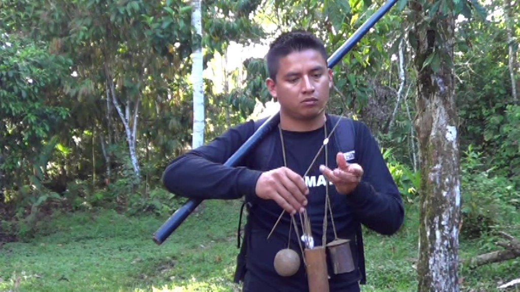 Our guide holds a dart gun over his shoulder and holds the dart