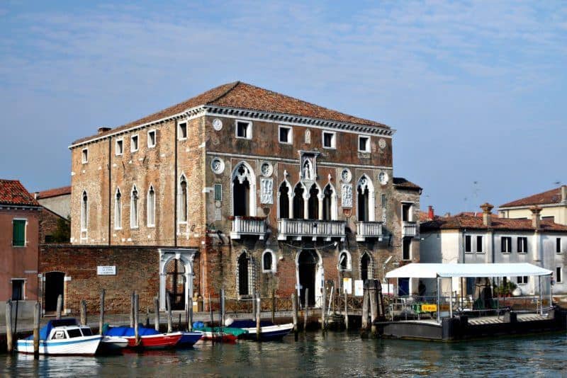 The facade of Mula Palace opens onto a narrow walkway that runs along the waterfront