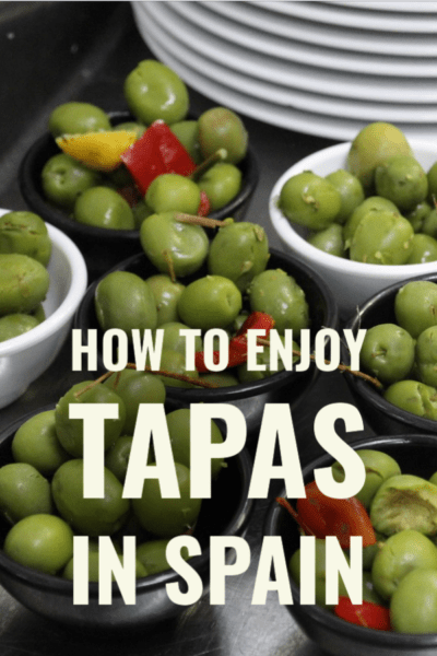 small bowls of green olives with text overlay "how to enjoy tapas in Spain"