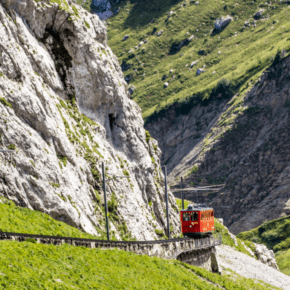 Red train goes down the track on Mount Pilatus.
