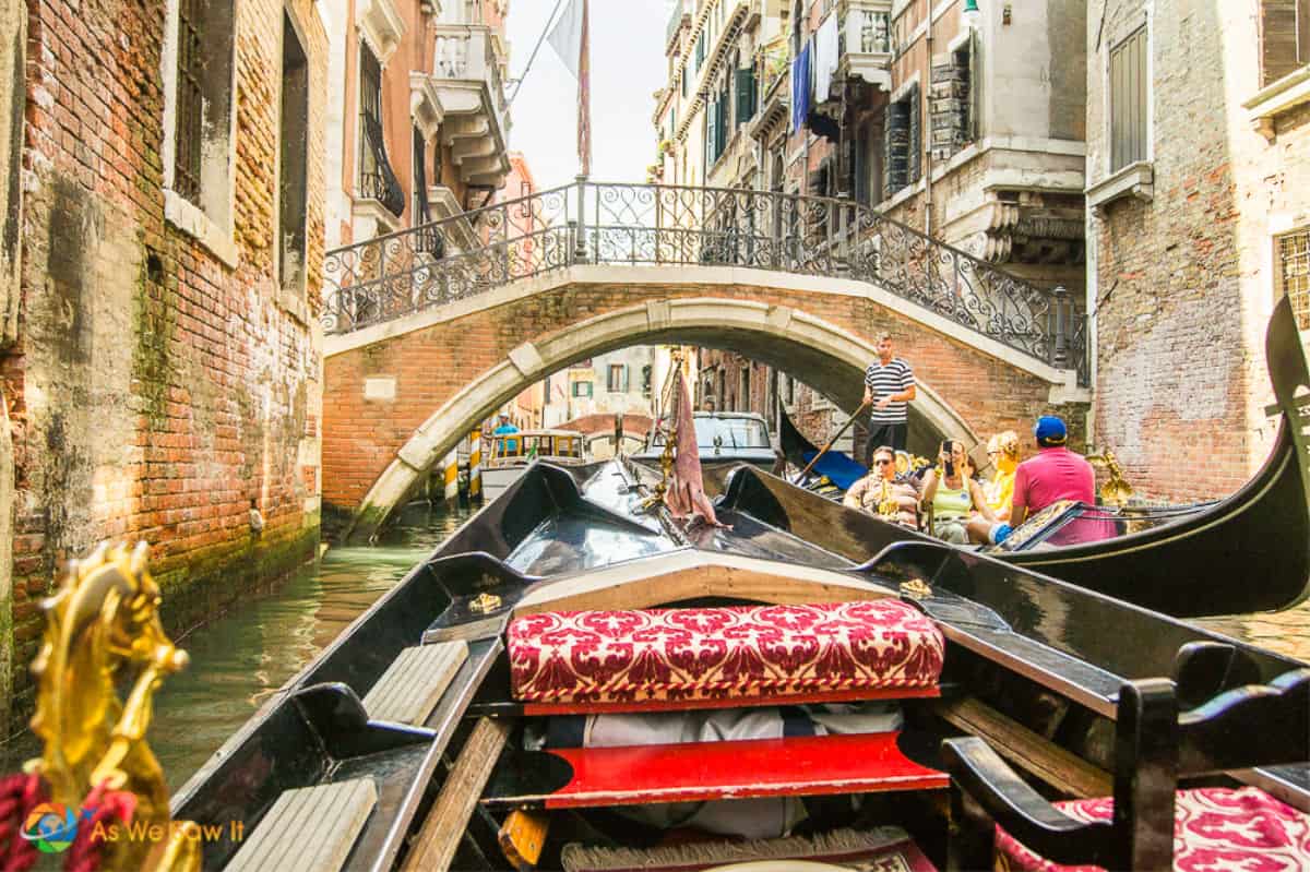 Front of Venetian gondola, as seen by passenger. Bridge and oncoming gondola in background