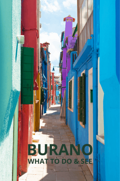 Colorful houses line a sidewalk in Burano Italy. Text overlay says Burano What to See & Do