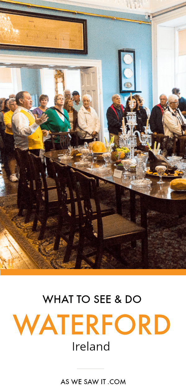 Visitors listen to actor in period clothing talking about his role at the Bishop's Palace. Dining table and chairs in foreground set with china, crystal and silver. Below is a subtitle box that says What to see and do Waterford Ireland. As We Saw It dot com.