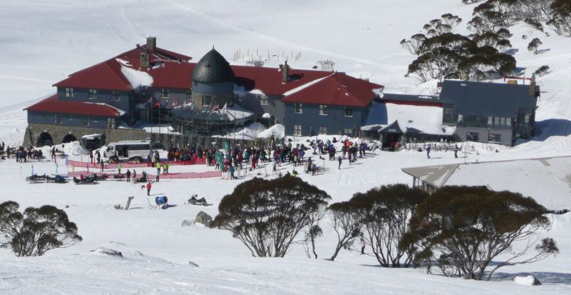 Grey ski lodge with red roof at Charlotte Pass, one of Australia's best ski slopes.