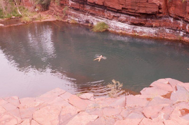 Long distance view of a woman floating in a lake.