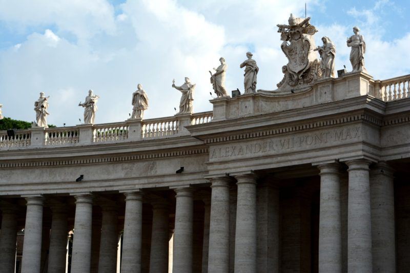 When visiting Vatican City, you can't miss the statues and columns surrounding St. Peter's Square. Here, you can see detail of a section of the colonnade around Piazza San Pietro. The text over the entry says Alexander VI Pont. Max.