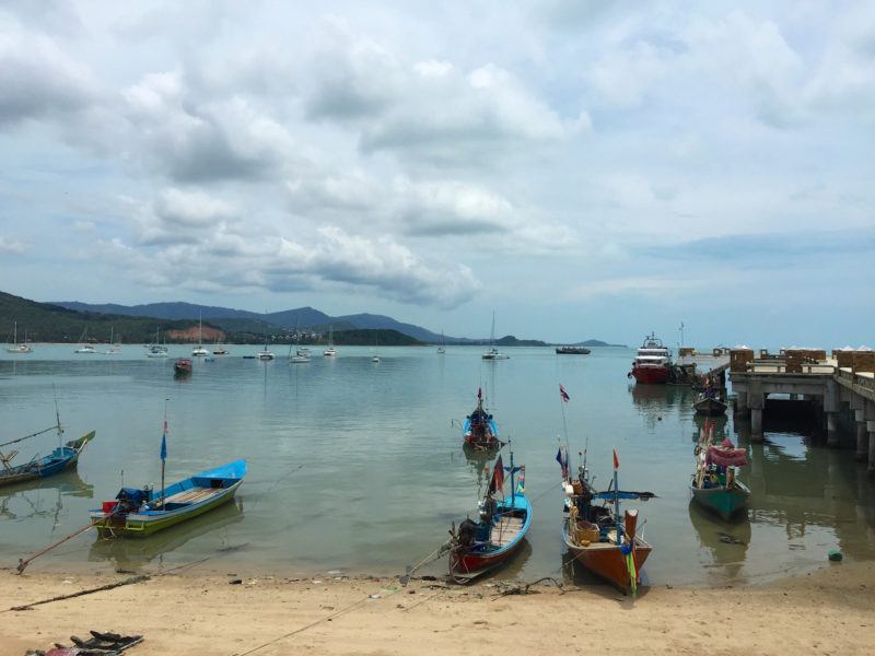 small motorboats near a pier on Big Buddha Beach Koh Samui