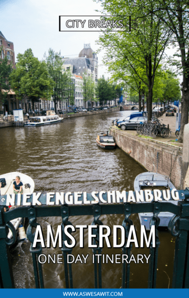 bicycle parked on bridge over a boat-lined canal in amsterdam