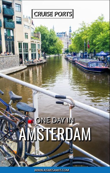 Amsterdam canal with cruise tour boats park along edge. Bicycle on bridge in foreground