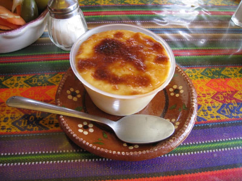 Jericalla flan with toasted top, in cup on plate with spoon