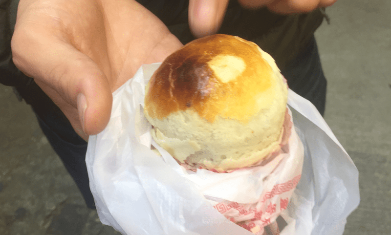 Holding a century old egg, wrapped in a biscuit-pastry coating 