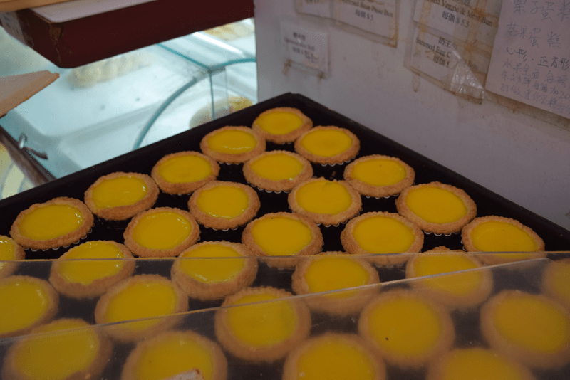 A baking tray of egg tarts, popular Hong Kong street foods, due to Portuguese influences.