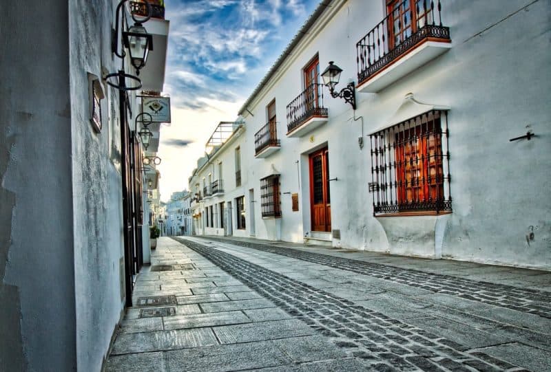 Narrow cobbled street with whitewashed houses in Mijas Spain