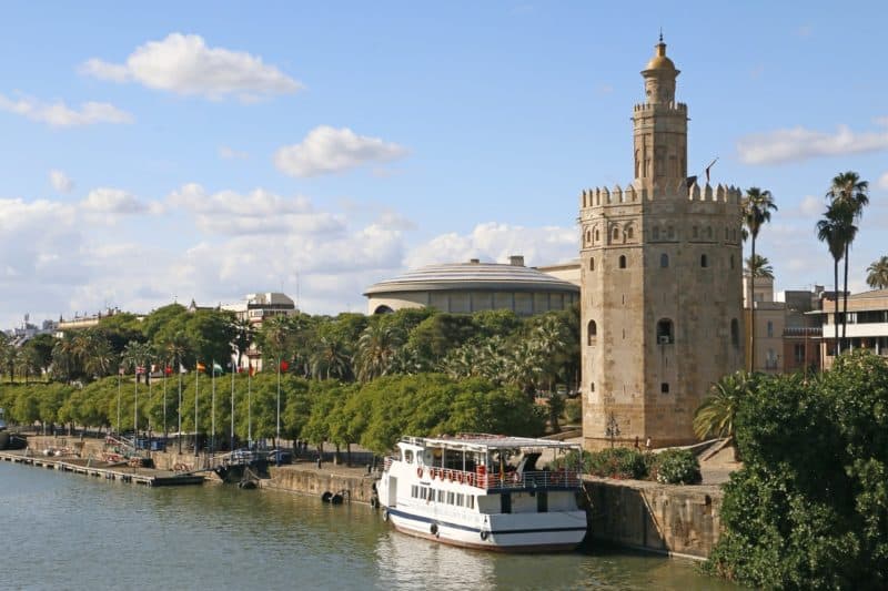 Tour boat docked next to a tower in in Seville, Spain south