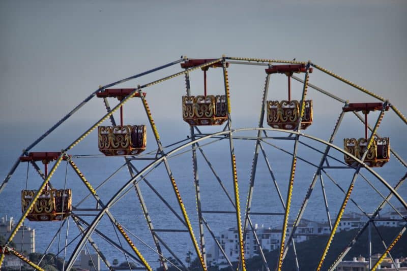 Top cars of a ferris wheel with a view of Spain's Mediterranean coastline and sea