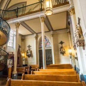 Spiral staircase and pews in the back of Loretto Chapel