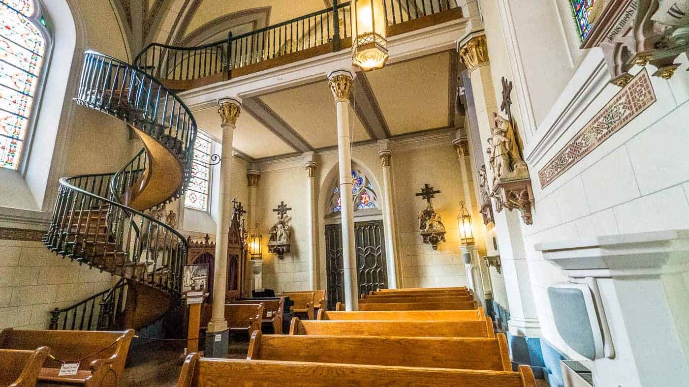 Spiral staircase and pews in the back of Loretto Chapel