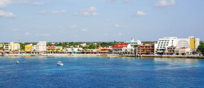 Fiew from the water of the shoreline of San Miguel, the largest city in Cozumel Mexico. Buildings line the water.