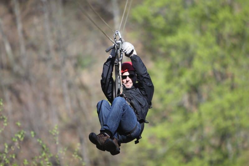 Closeup of man ziplining through the jungle