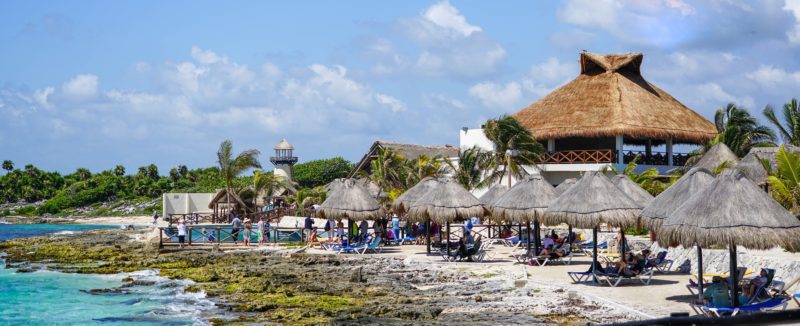 Cozumel beach with thatch umbrellas sheltering lounge chairs