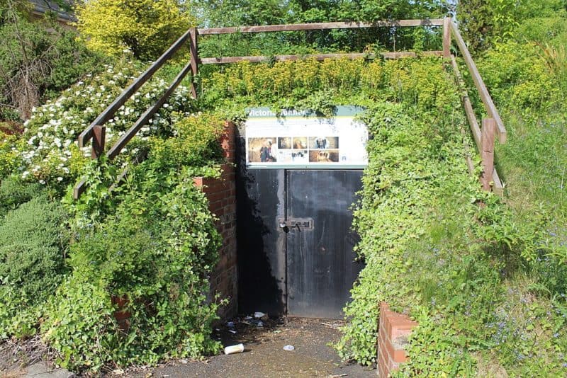 Doorway recessed into hillside with sign overhead that says Victoria Tunnel