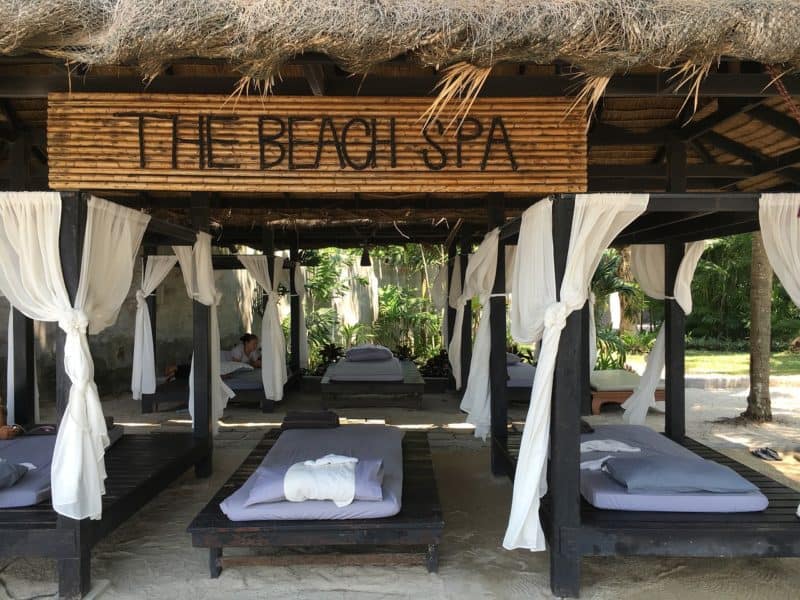 open air pavilion with beds and sign saying the beach spa