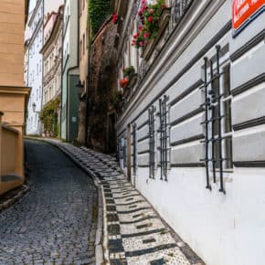 Street and decortive sidewalk curve out of sight on a street in Prague