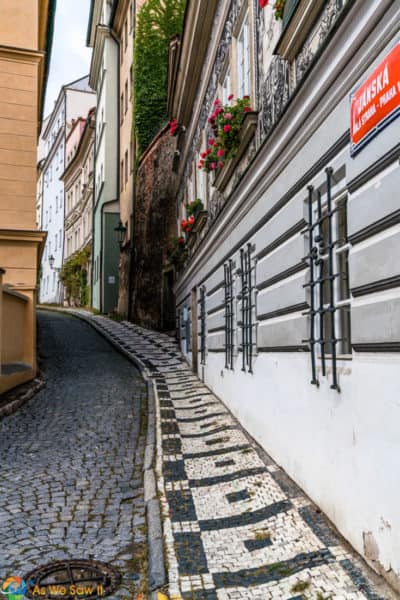 Street and decortive sidewalk curve out of sight on a street in Prague