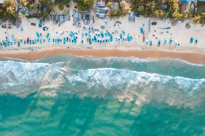 Aerial view of water and people on the beach at Arugam Bay