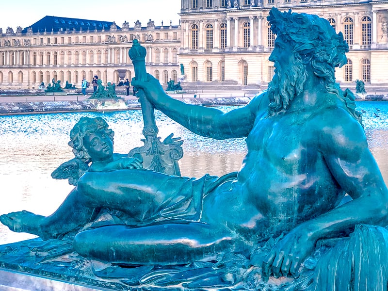 Statue and fountain at the gardens of Versailles