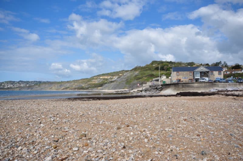 rocky beach in the foreground leading to a beach-side building