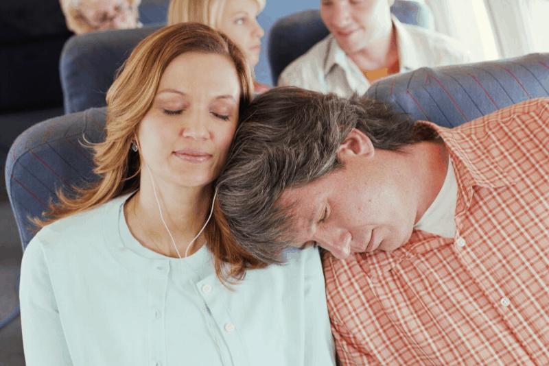 couple on a plane sleeping, one of the best tips to avoid jet lag