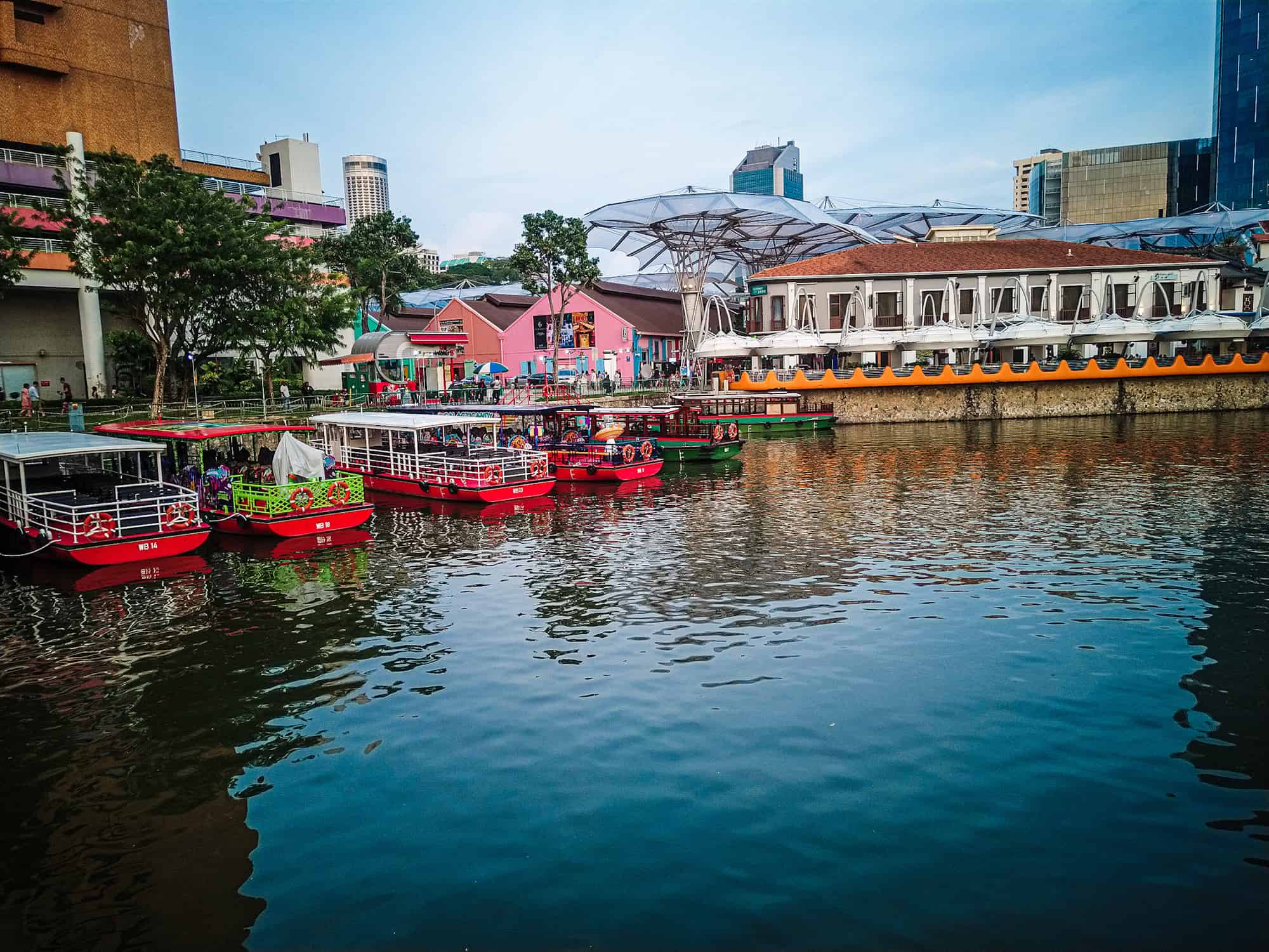 River cruise boats lined up on the singapore river at sunset