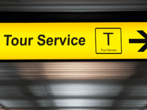 illuminated sign on an airport ceiling that says tour service