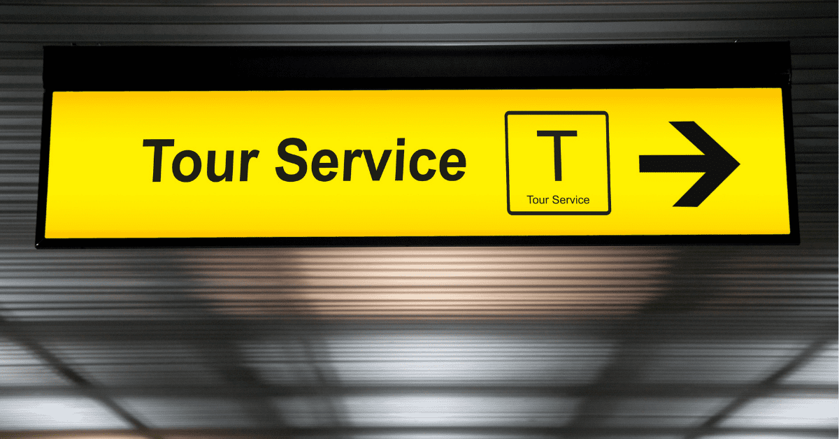 illuminated sign on an airport ceiling that says tour service