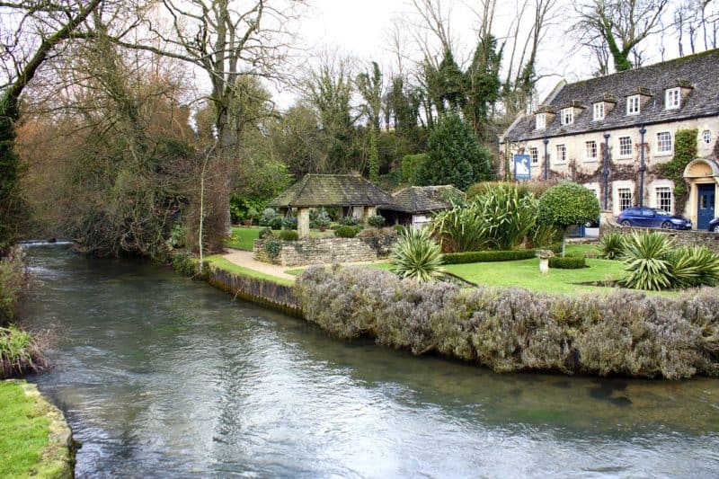 shallow creek next to cottages in the cotswolds