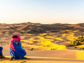 Bedouins enjoying the sunset across the Sahara sand dunes.