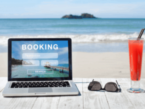 laptop with sunglasses and a drink on the beach. text says booking