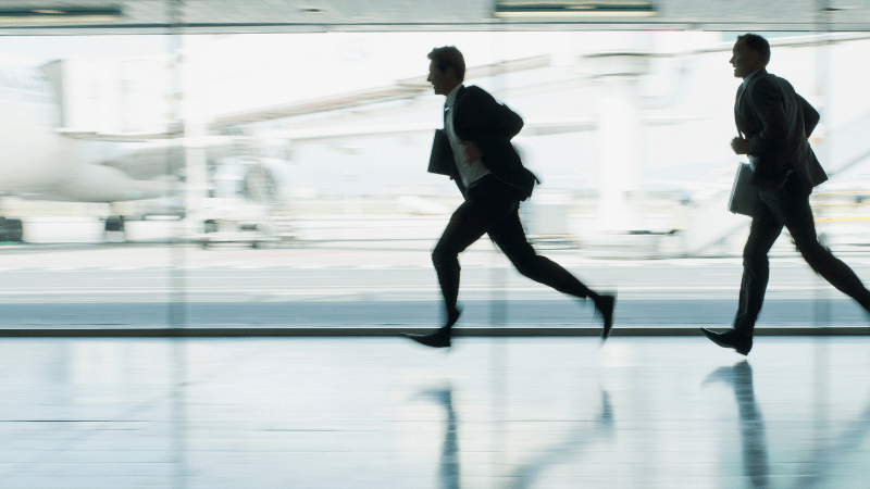 Two men running through airport to catch a plane