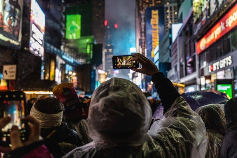 Woman taking a photo at times square in NYC in winter