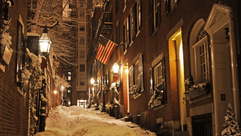 Boston row houses with snow on the sidewalk.