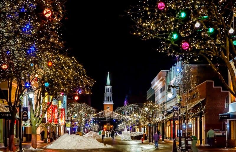 Pedestrian area of Burlington at Christmastime with piles of snow on the sidewalk. Keywords: New England vacation packages, vacations in december cheap getaways december cheap new england vacations.