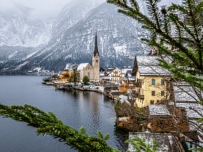 Hallstatt in winter as seen through the branches of an evergreen