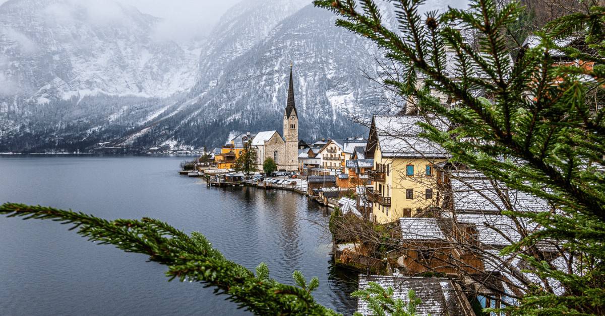 Hallstatt in winter as seen through the branches of an evergreen