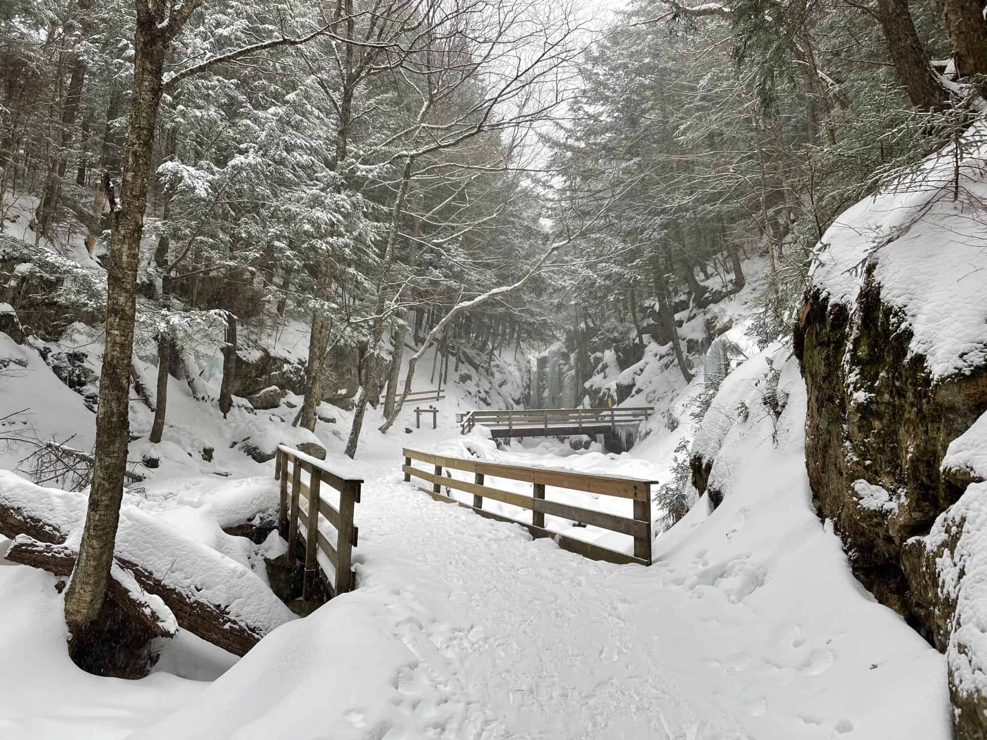snow covered path with wooden bridges, for a winter vacation in New England