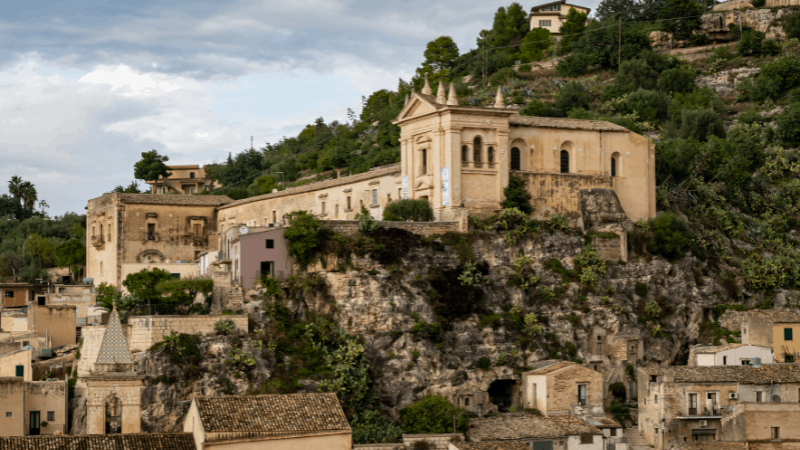 church and houses on the side of a hill in Scicli Sicily