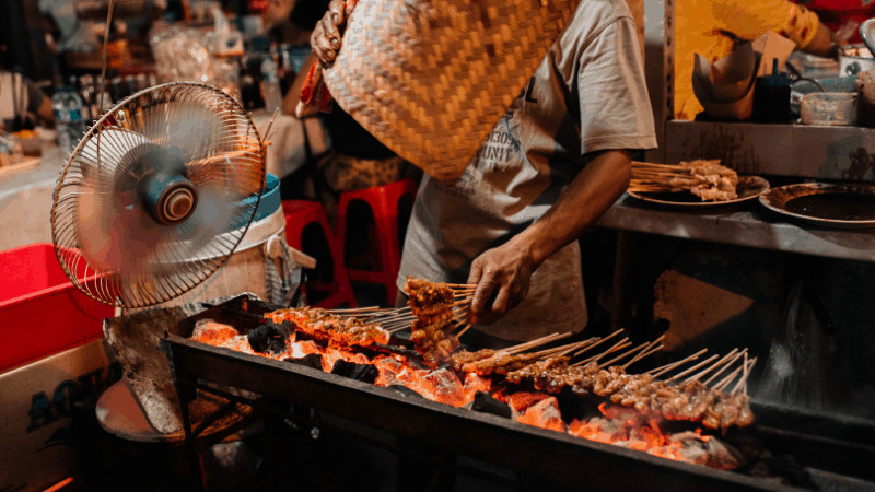 grill with skewers of satay over hot coals